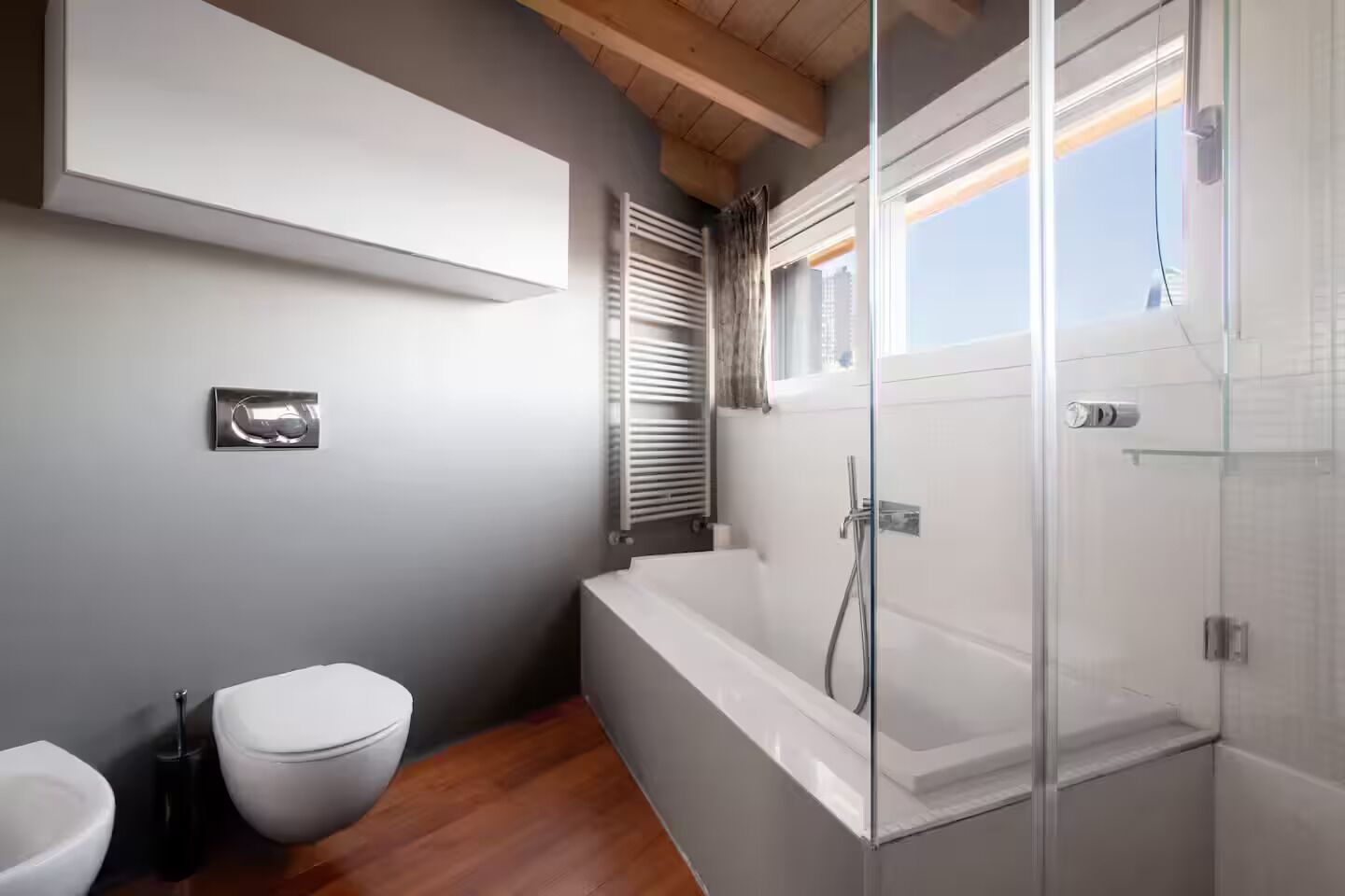 Ein modernes Badezimmer mit Badewanne, Toilette und Duschbereich.