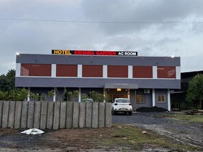 Un edificio moderno con un letrero que dice 'HOTEL KRISHNA GARDEN AC ROOM'.