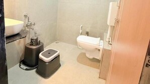 Un baño pequeño con inodoro, lavamanos y ducha.