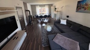 En moderne stue med et fladskærms-tv, en sofa, et tæppe og en pejs.
