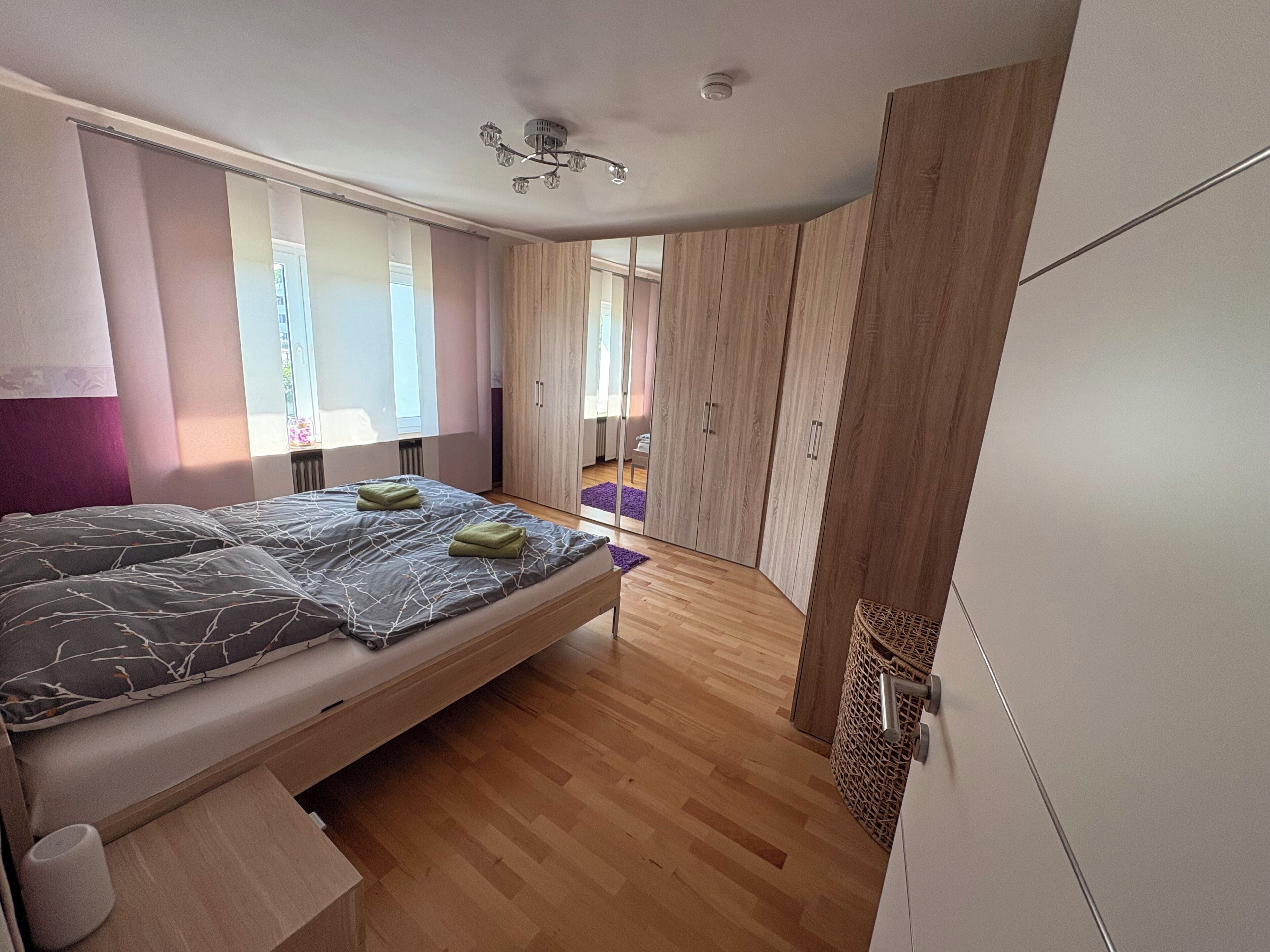 Ein Schlafzimmer mit einem Bett, einem Holzschrank und einem Fenster.