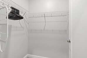 A closet with a metal rack and a tennis racket.
