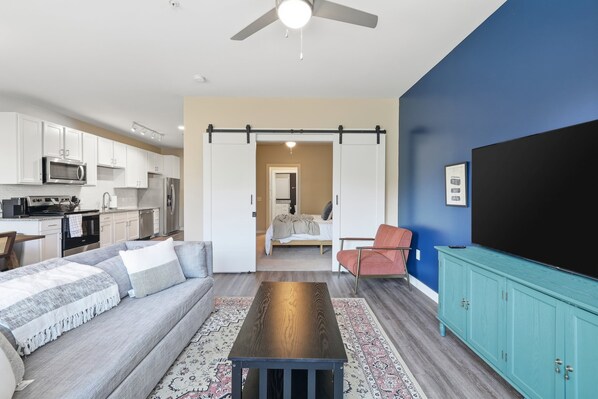 Un espacio habitable moderno con cocina, comedor y un dormitorio.