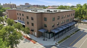 A multi-story building with a flat roof, large windows, and a brick facade.
