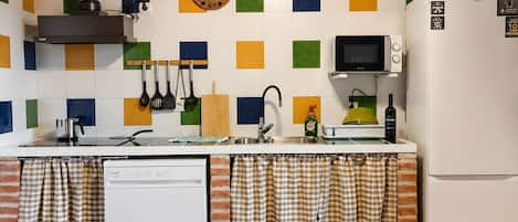 Una cocina con techo de madera, estufa, microondas, refrigerador y lavavajillas.