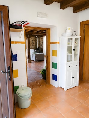 A kitchen with a stove, cabinets, and a potted plant.