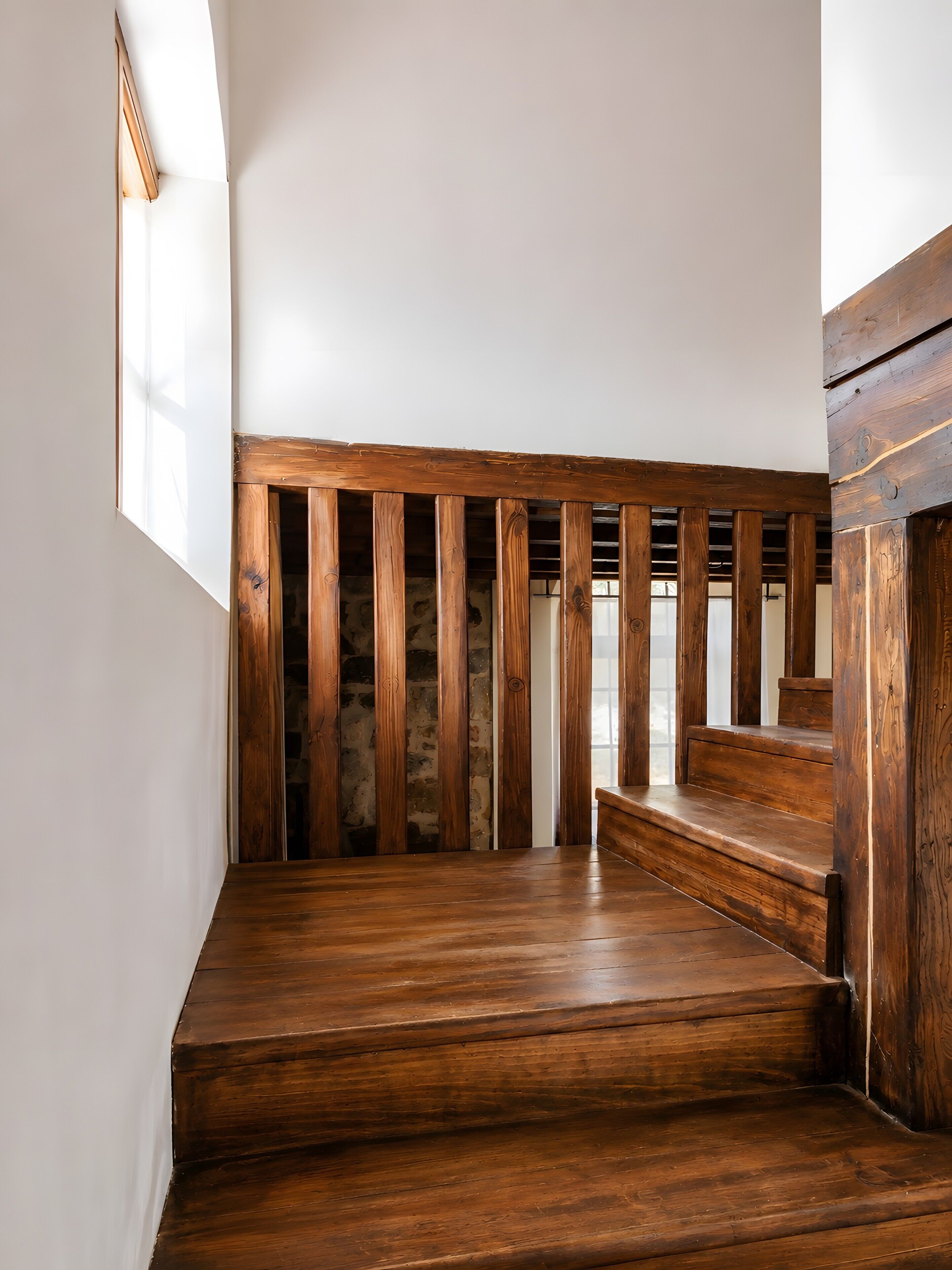 Una escalera de madera con un fondo de pared de piedra.