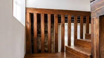 Una escalera de madera con un fondo de pared de piedra.