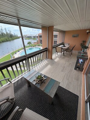A balcony with a view of a swimming pool and a river. - TOP-FLOOR WATERFRONT CONDO GETAWAY (Punta Gorda)