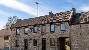 A stone building with a tiled roof, multiple windows, and a small entrance. - Berwick - Close to Town, Bridges and Train Station (Berwick-upon-Tweed)