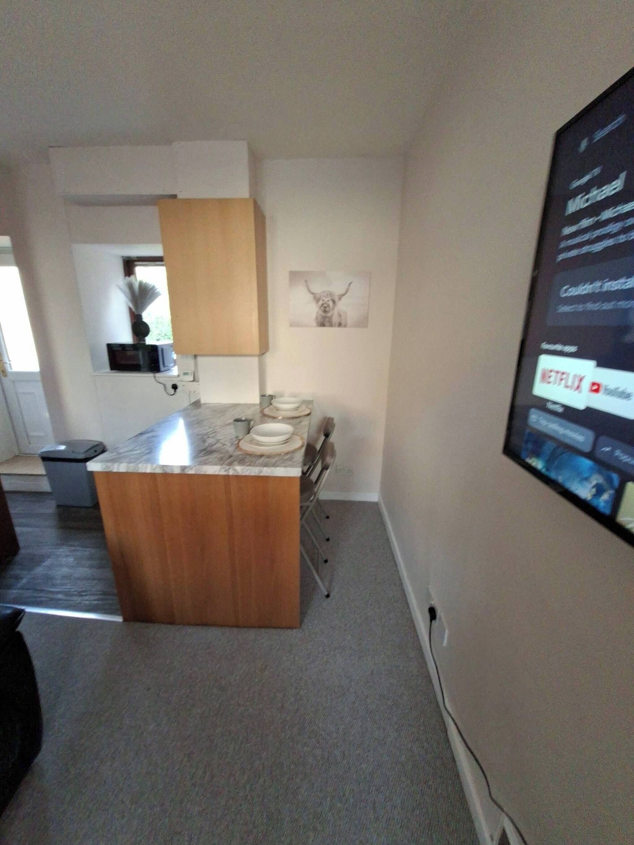 Eine moderne Küche mit einer Holztreseninsel, einer Mikrowelle und einem gerahmten Bild an der Wand.