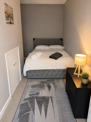 A neatly arranged bedroom with a bed, bedside table, lamp, and a small potted plant. - Berwick - Close to Town, Bridges and Train Station (Berwick-upon-Tweed)