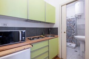 A compact kitchen with a microwave, sink, and cabinets. - Charming suite with a view in the heart of Rome (Roma)