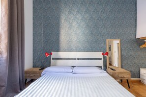 A hotel room with a bed, bedside tables, a mirror, and a wardrobe. - Charming suite with a view in the heart of Rome (Roma)