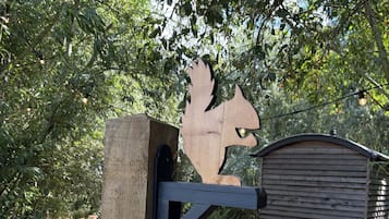 A wooden structure with a metal gate and a wooden sign that reads 'Squirrel.'