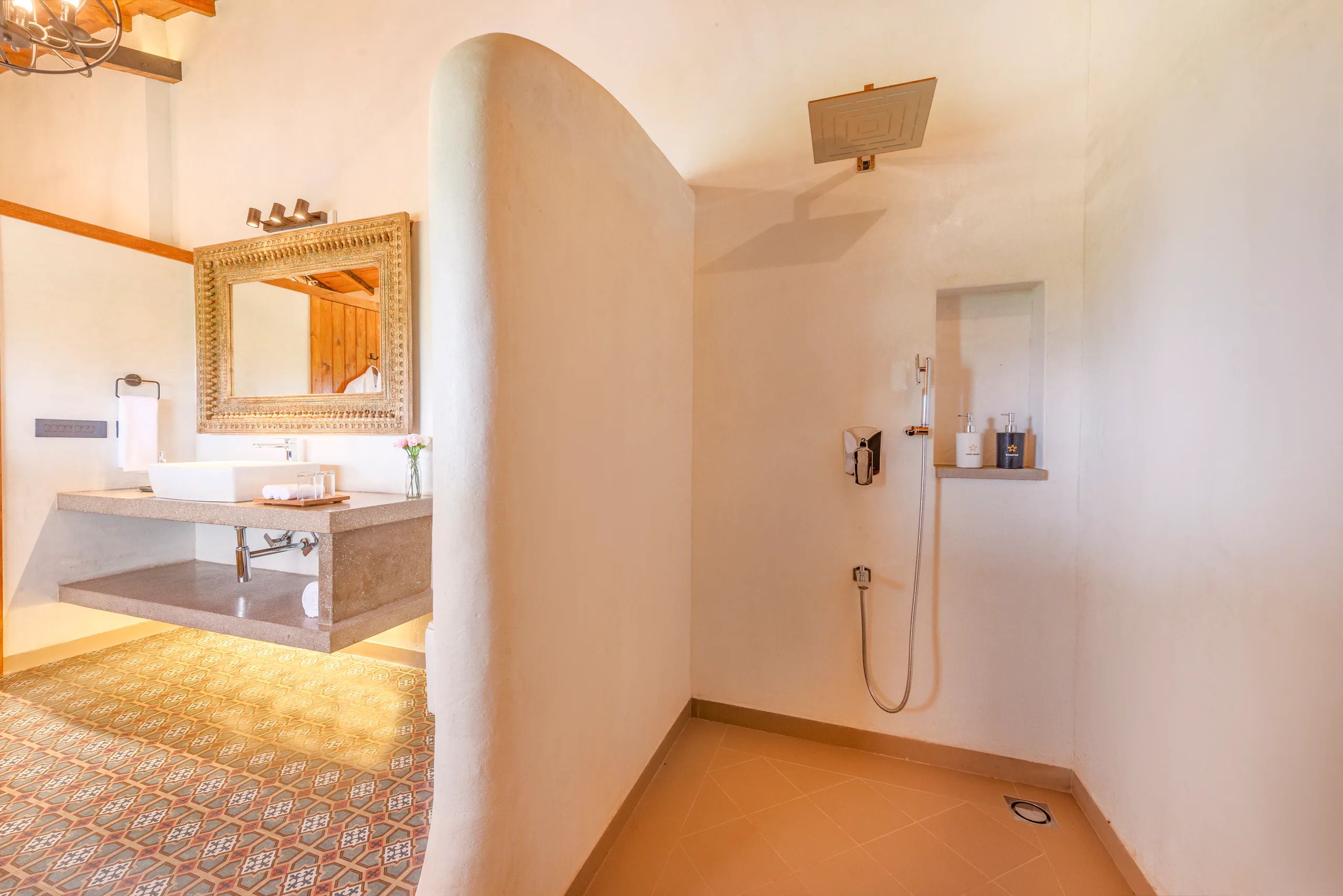 A bathroom with a large mirror, a sink, and a shower.