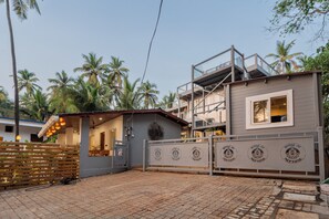 Uma casa moderna de dois andares com varanda, alpendre coberto e portão fechado.