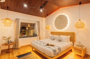 Quarto com cama de madeira, ventilador de teto e duas luminárias de cabeceira.