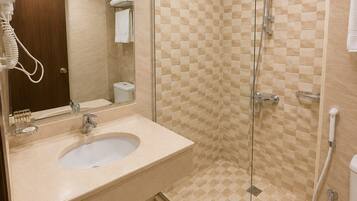 Een badkamer met een douchecabine van glas, een wastafel met spiegel en een toilet.