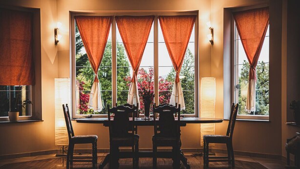 A dining area with a round table, four chairs, and a vase of flowers. - Hide Away in a Private Countryside Villa (Postojna)