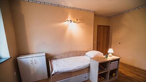 A small bedroom with a bed, a nightstand, a cabinet, and a wall-mounted light fixture. - Hide Away in a Private Countryside Villa (Postojna)