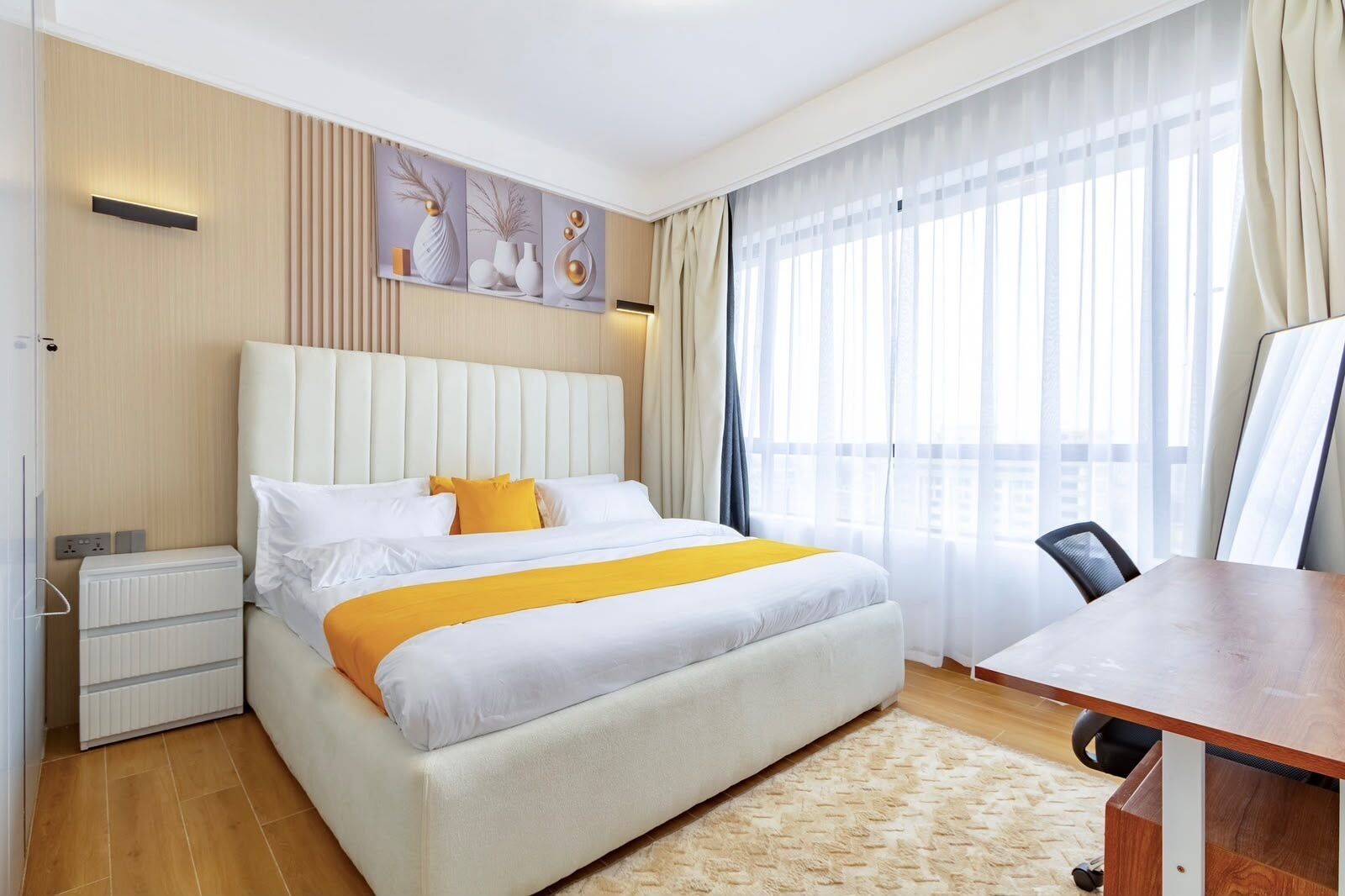 Una habitación de hotel con una cama grande, un escritorio y una ventana con cortinas.