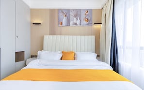 Habitación de hotel con cama, cabecero, mesita de noche y ventana con cortinas.