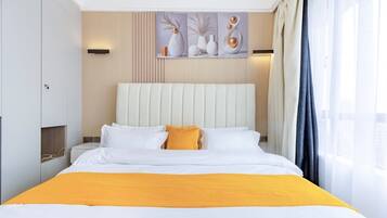 A hotel room with a bed, a headboard, a nightstand, a wall-mounted light, and a window with curtains.