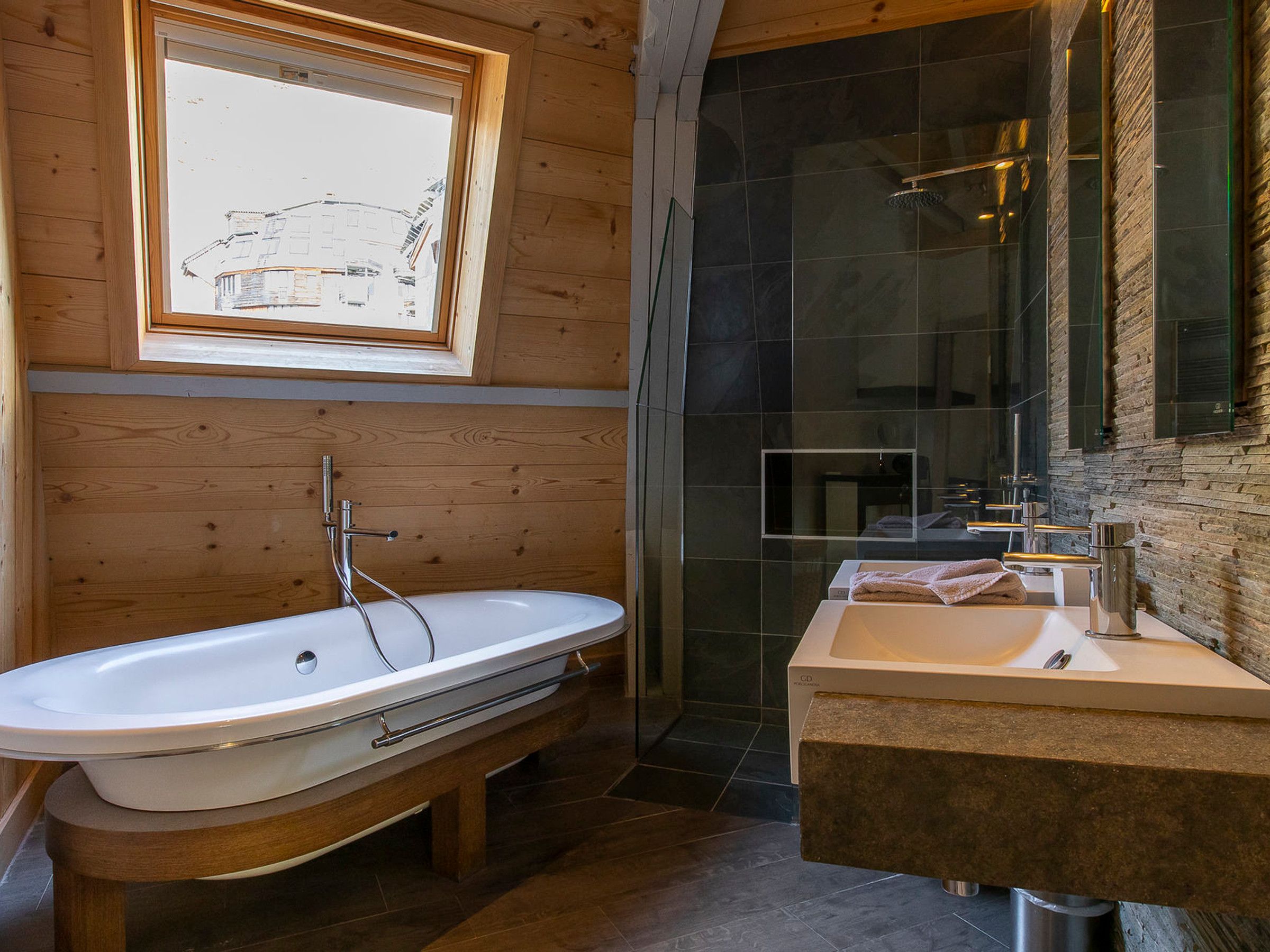 A bathroom with a freestanding bathtub, a sink, and a shower area.