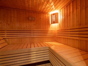 Eine Sauna mit Holzbänken und einem Wandheizkörper.