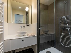 A modern bathroom with a large mirror, a white sink, and a glass-enclosed shower area. - Exceptional chalet, central location - 10 guests (Avoriaz)