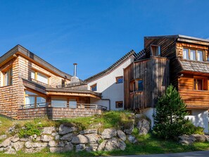 A wooden cabin with a stone foundation, large windows, and a sloped roof. - Exceptional chalet, central location - 10 guests (Avoriaz)