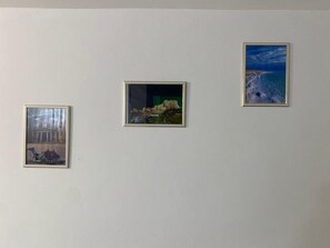 Three framed artworks on a plain wall.