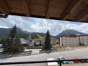Blick auf eine gebirgige Gegend mit Gebäuden und einem Parkplatz.