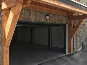 Uma garagem com estrutura de madeira e parede de pedra.