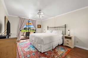 Une chambre à coucher avec un lit, une table de chevet et un téléviseur posé sur un meuble.