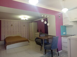 A bedroom with a bed, a desk, and a chair. There is a wardrobe and a small kitchenette. - Perfect 1-bedroom house with AC in adorable Yerevan neighborhood (Yerevan)