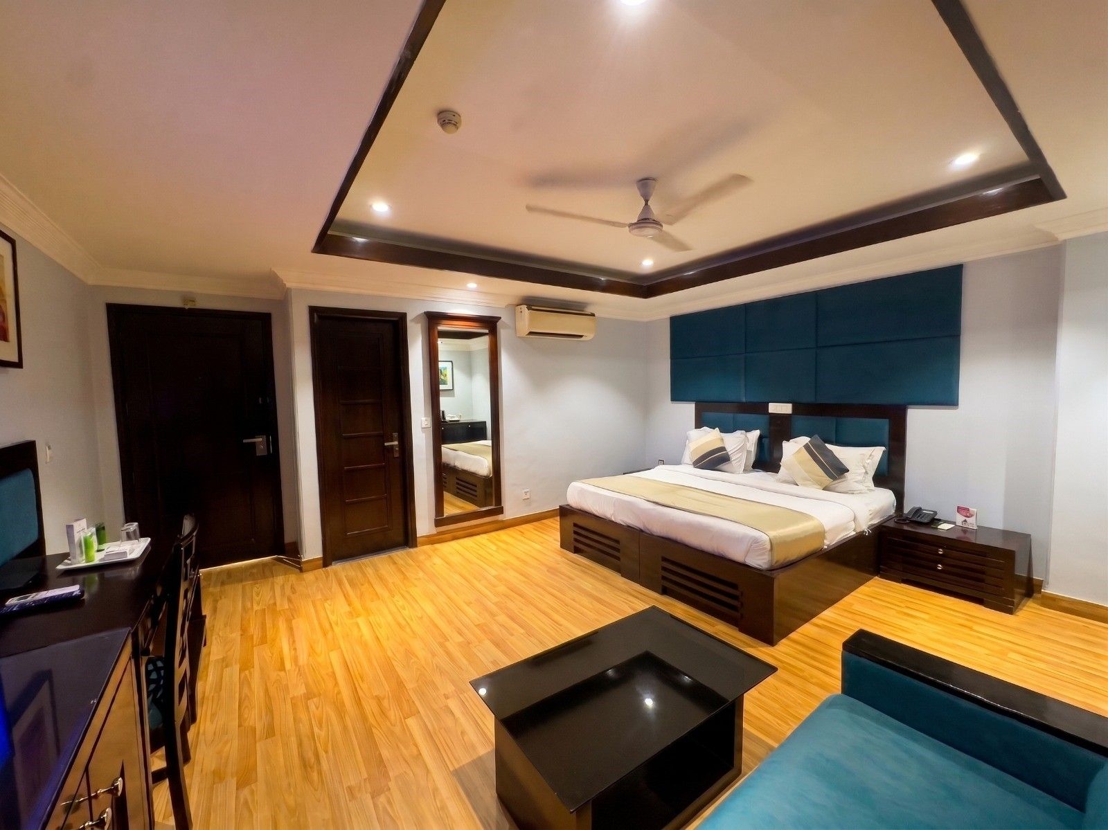 Una habitación de hotel moderna con cama, mesita de noche y ventilador de techo.