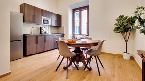 A modern kitchen with dark wooden cabinets, a stainless steel refrigerator, and a microwave.
