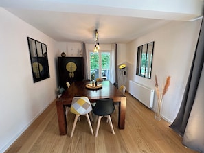 A dining area with a wooden table, chairs, a cabinet, and a floor lamp.