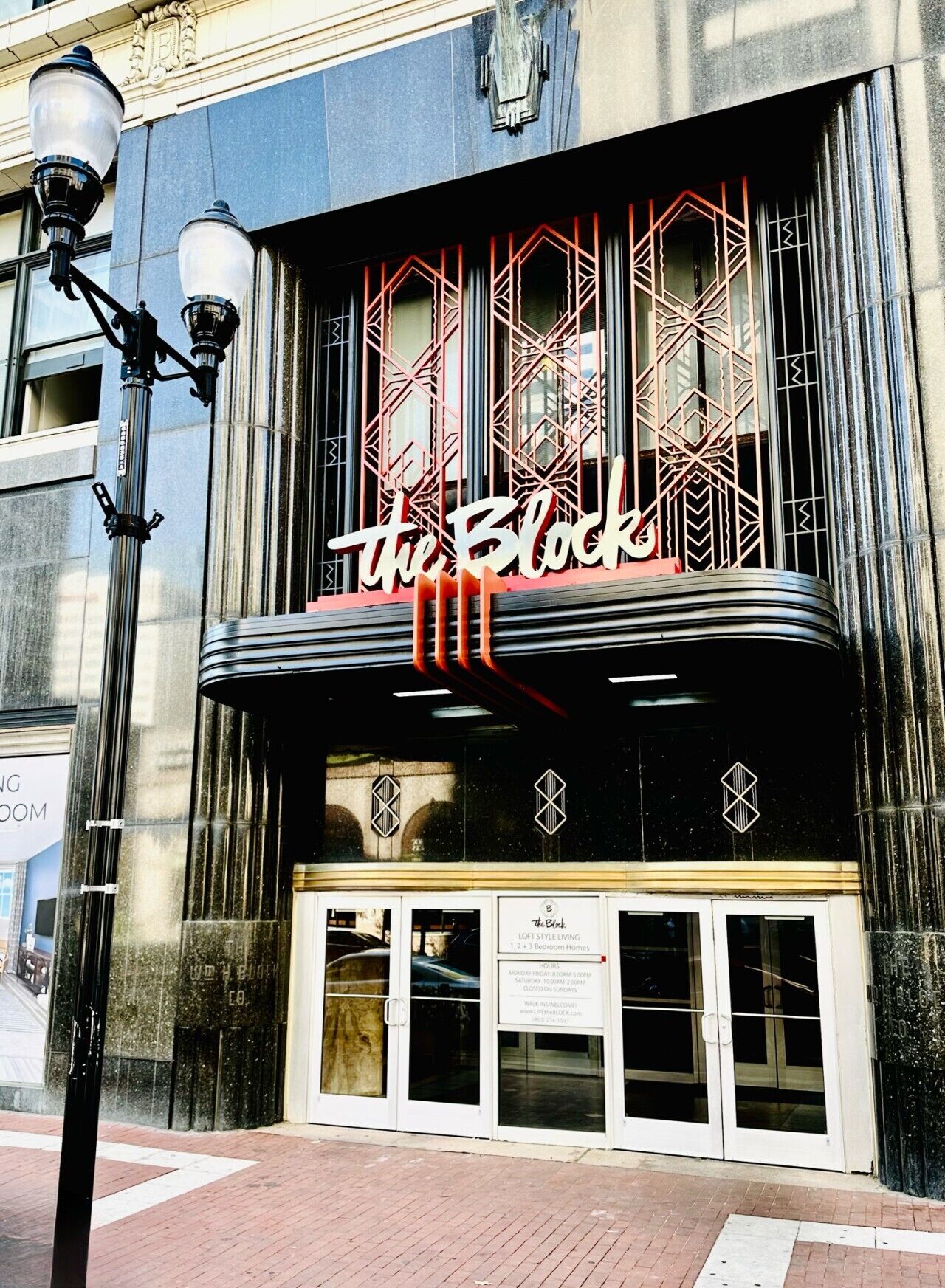 Un edificio con una tenda da circo che recita 'The Block' e un cartello che pubblicizza appartamenti in stile loft.
