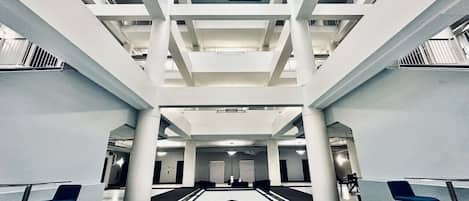 Un hall d’entrée spacieux avec une table de billard centrale, de hauts plafonds et un design architectural moderne.