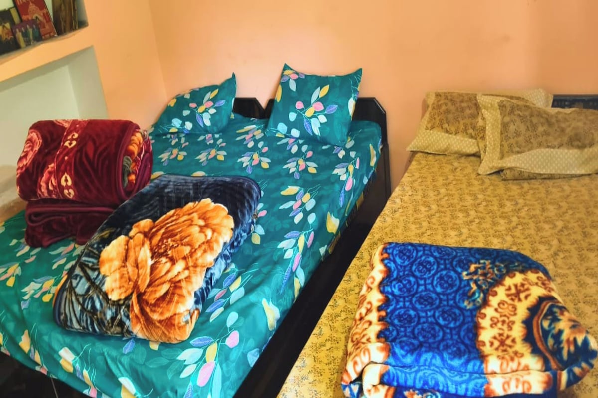 Una habitación con dos camas, cada una con ropa de cama floral diferente.