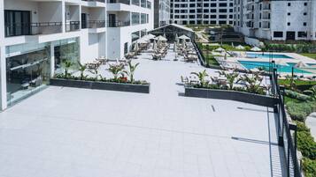 Une terrasse sur le toit avec des espaces de détente en plein air et une piscine.