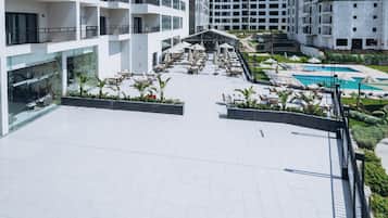 A rooftop terrace with outdoor seating, a swimming pool, and a landscaped garden.