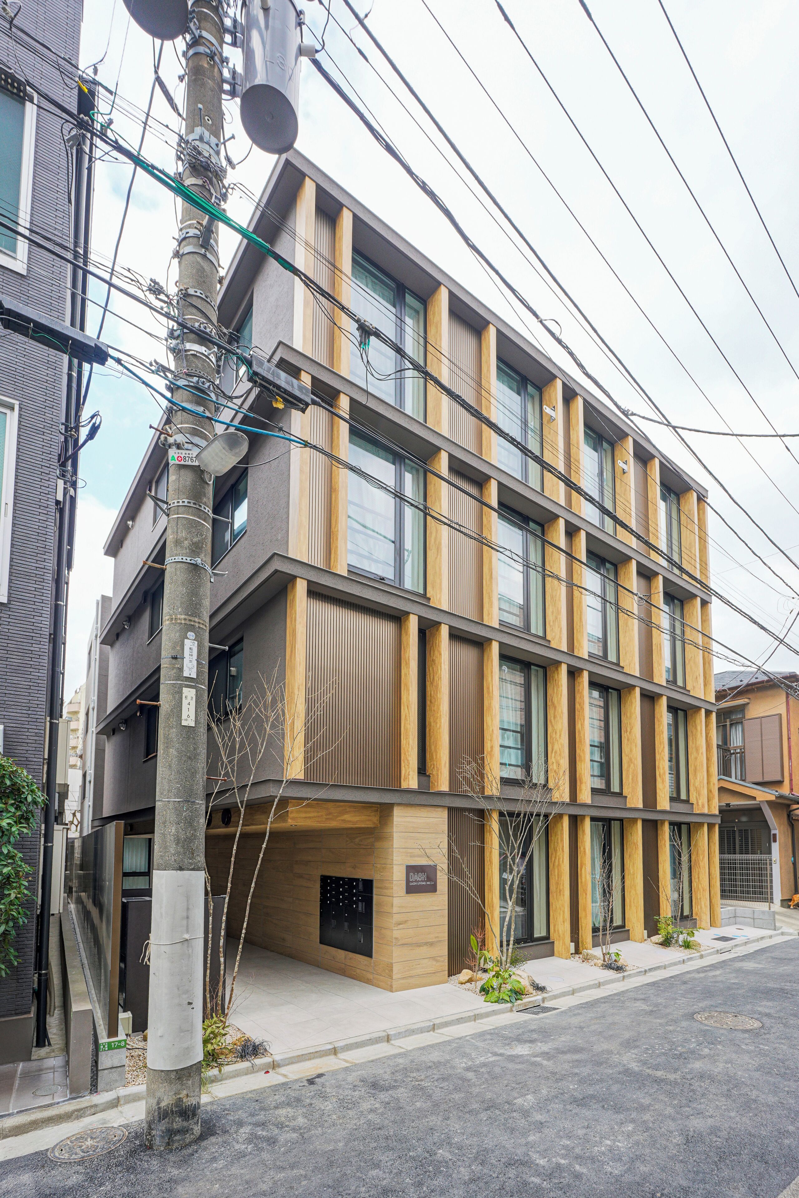 A multi-story building with a modern architectural design, featuring a combination of glass and wooden paneling.