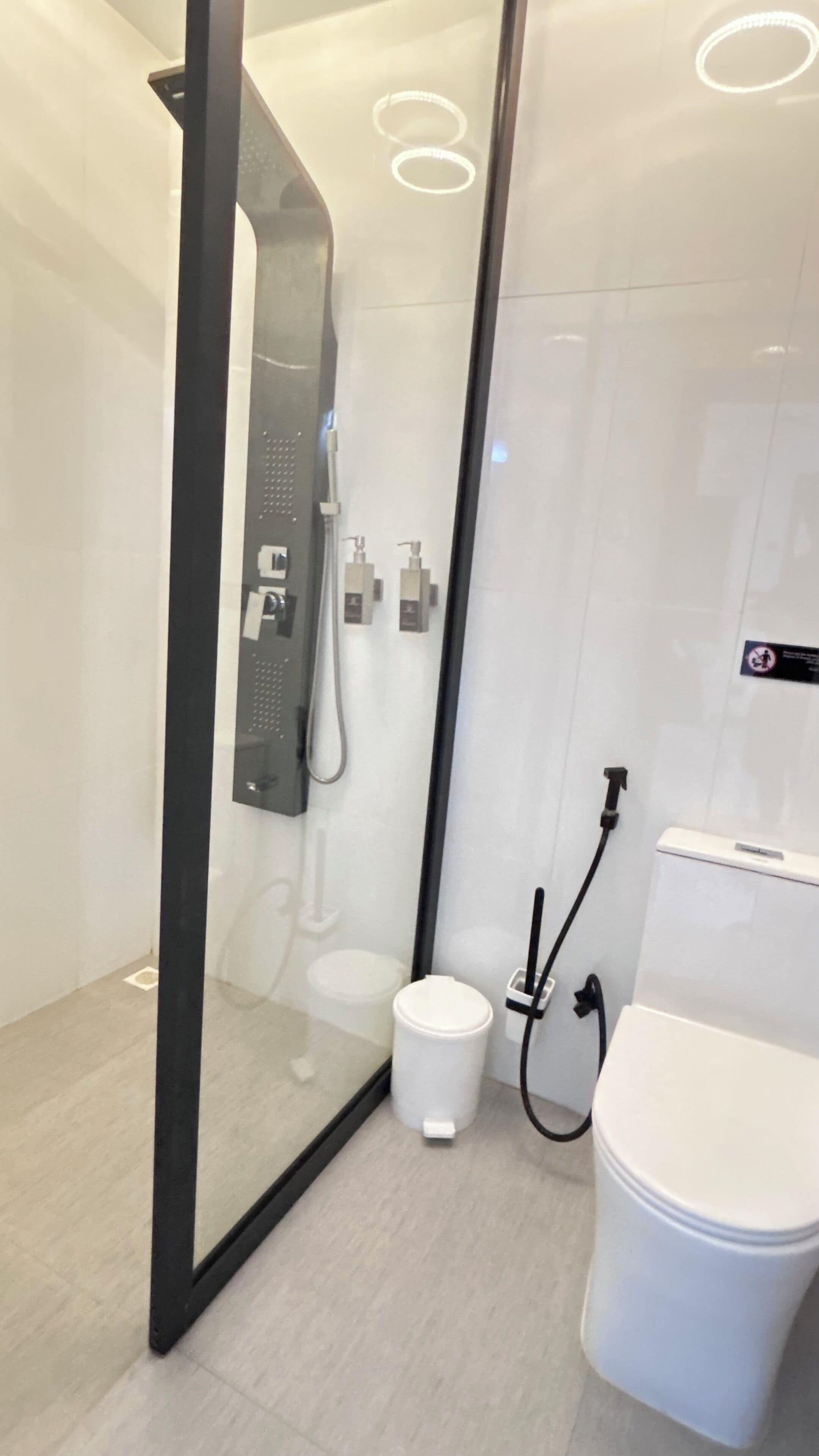 Un baño moderno con ducha envuelta en vidrio, un inodoro y un bidé.