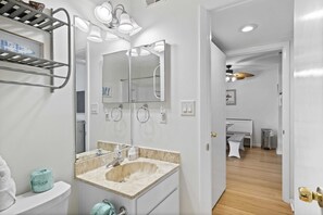 Uma casa de banho moderna com lavatório, espelho e porta-toalhas.