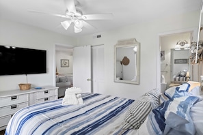 A bedroom with a bed, a ceiling fan, a television, a dresser, and a mirror. - Fiddler's Cove - 2 Pool -Tennis - Hot Tub - Gym - Walk to the Beach! (Hilton Head Island)