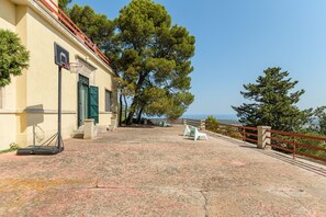A building with a basketball hoop, a paved area, and a view of the sea. - Villino alla Croce by Wonderful Italy (Ostuni)